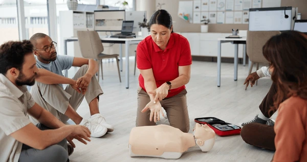 Hands performing CPR on a training mannequin